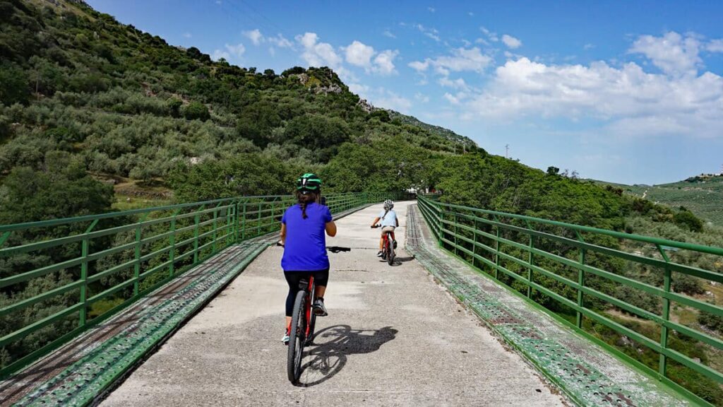 Family riding over the viaduct on teh via verde in Andalusia